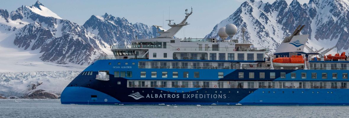 Albatros Expedition Cruise in Polar Landscape An Albatros Expeditions cruise ship navigating through a dramatic polar seascape with snow-capped