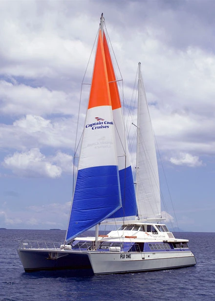 Captain Cook Cruises Catamaran Under Sail A striking catamaran sailboat with tri-color sails (orange, white, and blue) matching the Captain