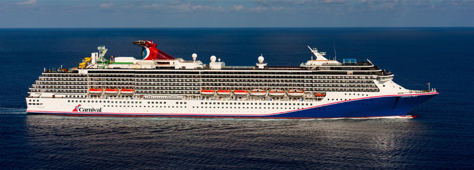 Carnival Cruise Ship at Sea A large white and red Carnival cruise ship sailing on open blue waters, showcasing the vessel's
