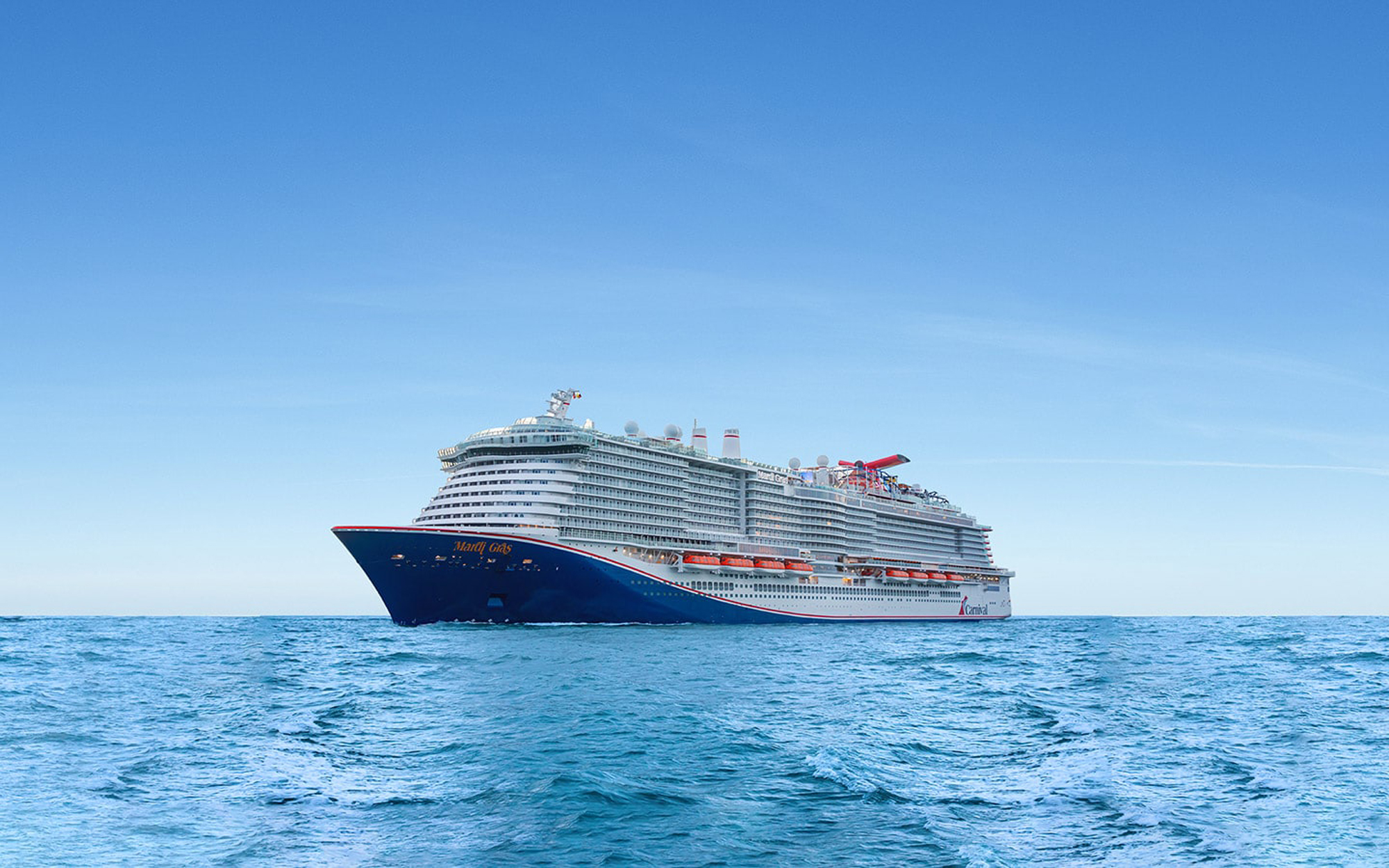 Carnival Cruise Ship on Blue Ocean A large, modern Carnival cruise ship sailing on calm, blue waters under a clear sky. The vessel