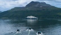 Cruise Ship in Glacier Bay Mountain Waters A white cruise ship anchors in pristine blue-green waters surrounded by snow-capped mountains