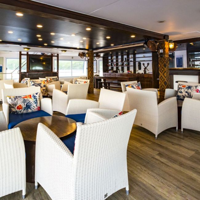 Luxury Cruise Ship Lounge and Bar Area An elegant indoor lounge and bar area aboard a luxury cruise ship, featuring cream-colored wicker