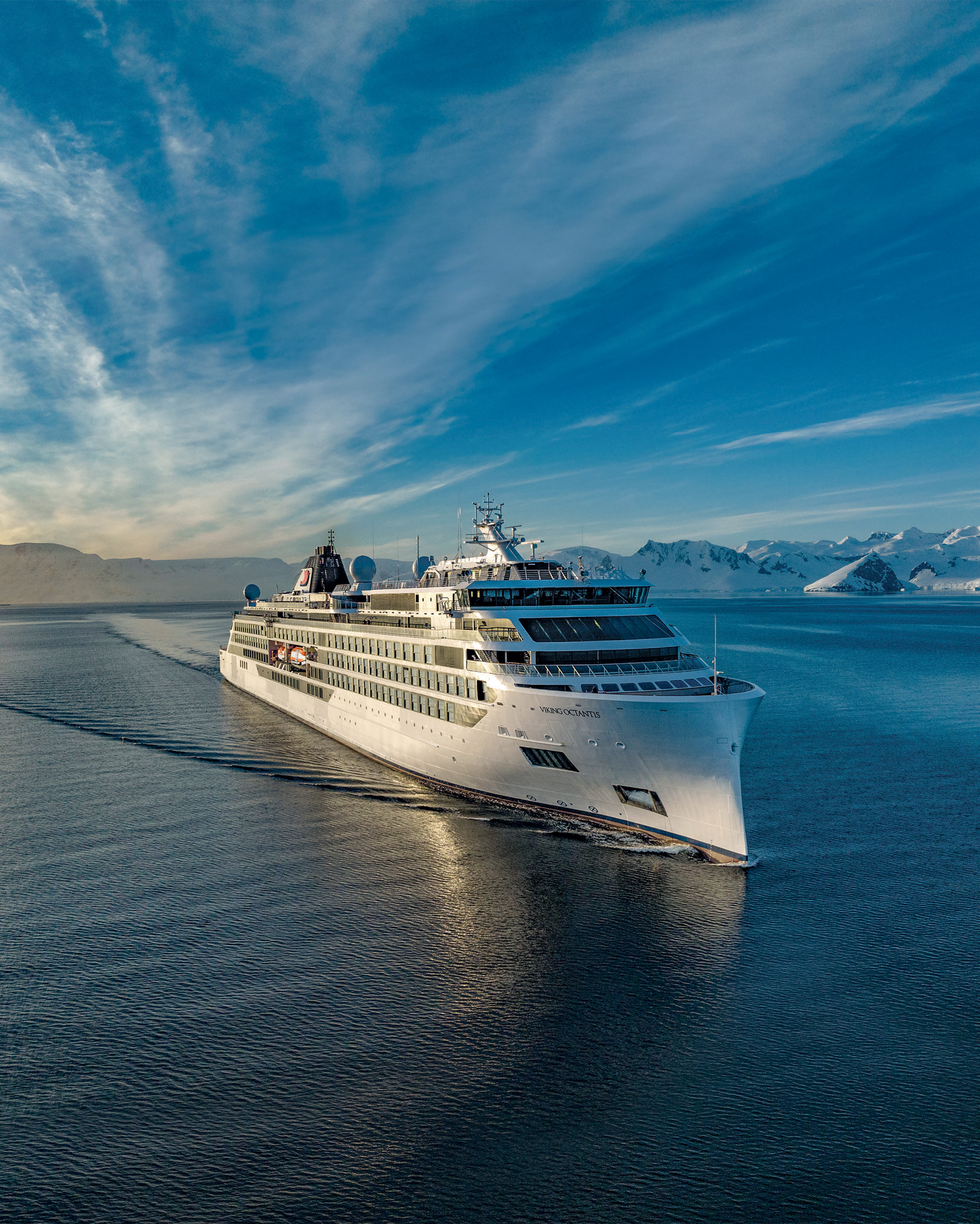 Luxury Cruise Ship in Arctic Landscape A luxury cruise ship sailing through Arctic waters surrounded by dramatic icy landscapes and mountainous terrain.