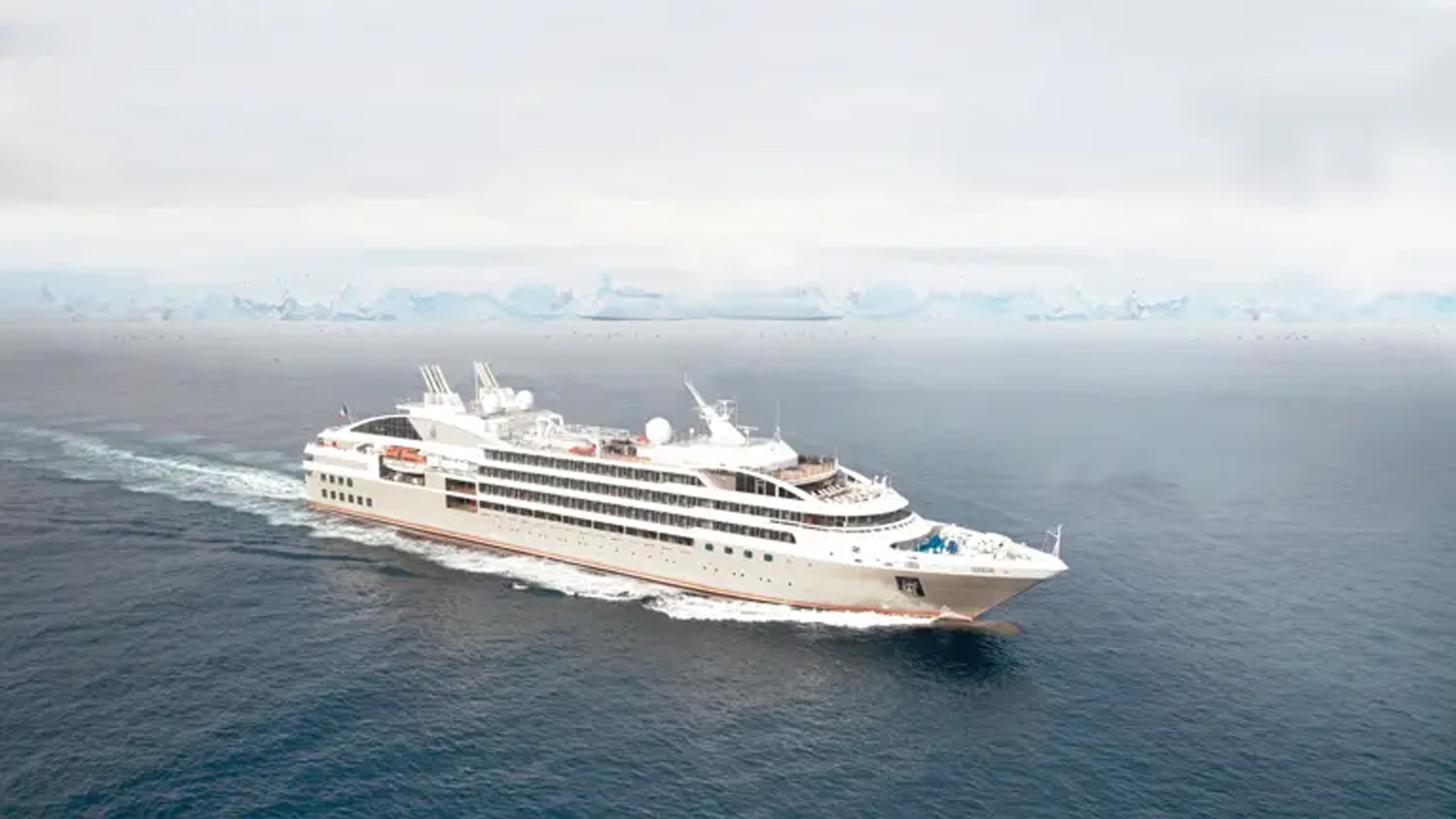 Luxury Expedition Cruise Ship in Polar Regions Luxury expedition cruise ship navigating polar waters with icebergs in the background.