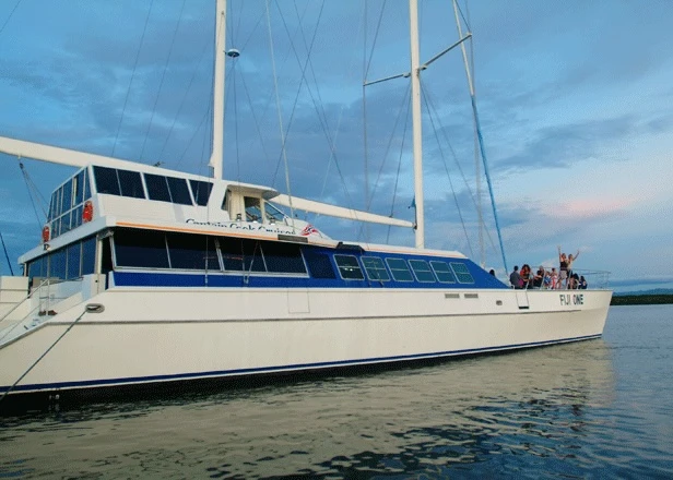 Luxury Gulet Sailing Vessel at Anchor A stunning white and blue gulet-style sailing yacht anchored in calm waters during golden hour
