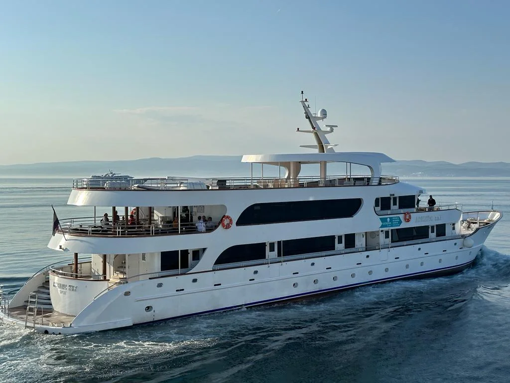 Luxury Motor Yacht Anchored in Mediterranean Waters A striking white multi-deck motor yacht with sleek modern design anchored in calm blue