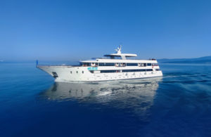 Luxury Motor Yacht in Azure Waters A sleek, white multi-deck motor yacht cruises through crystal-clear azure Mediterranean or tropical