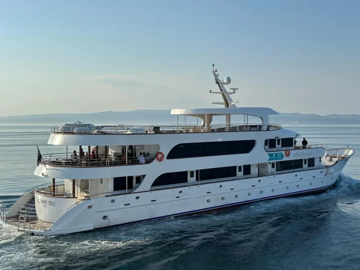 Luxury Motor Yacht in Calm Waters A elegant white motor yacht with multiple decks and modern amenities cruises through calm, clear