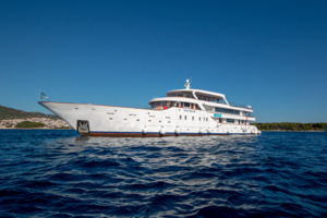Luxury Motor Yacht in Mediterranean Waters A white luxury motor yacht anchored in crystal-clear blue Mediterranean waters under a clear sky