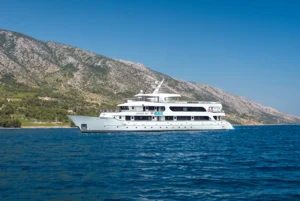 Luxury Yacht Anchored in Mediterranean Waters A pristine white luxury motor yacht anchored in crystal-clear turquoise Mediterranean waters with