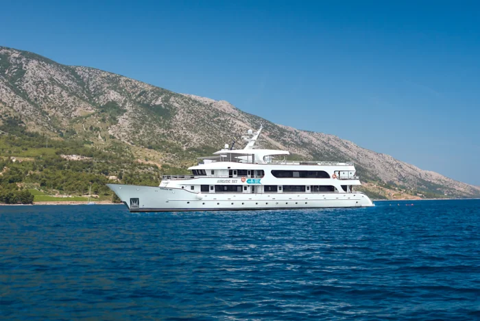 Luxury Yacht Anchored in Mediterranean Waters A pristine white luxury motor yacht is anchored in crystal-clear turquoise Mediterranean waters