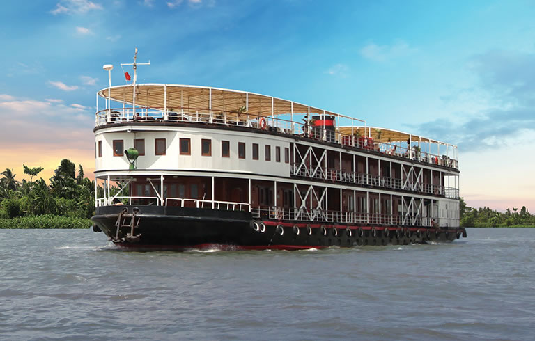 River Cruise Vessel on Tropical Waterway A multi-deck river cruise ship navigating through a lush tropical river landscape with verdant