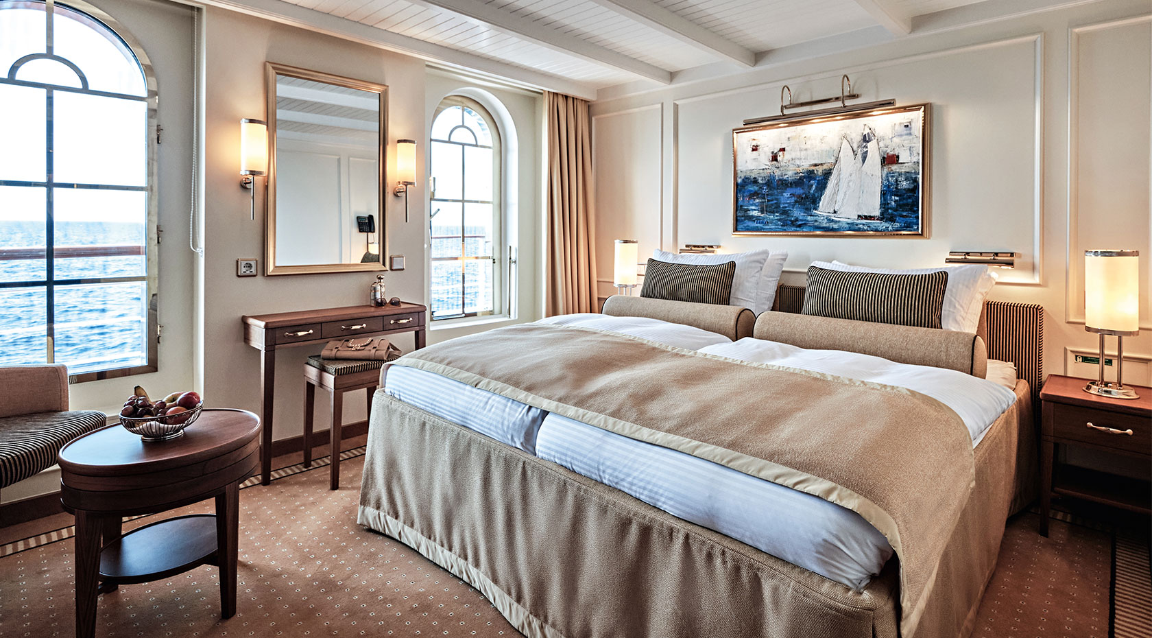 SCS_CA_CatC_003_iso_1680x930 An elegant Sea Cloud cabin with classic nautical decor and refined furnishings.