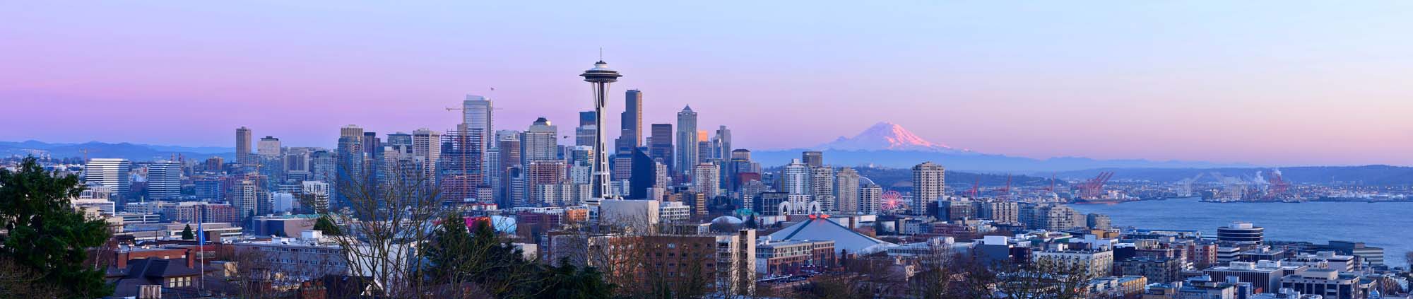 Seattle Skyline with Mount Rainier at Sunset A stunning panoramic view of Seattle's iconic skyline at sunset, featuring the Space Needle as the central landmark, with Mount Rainier visible in the distance and Puget Sound stretching across the foreground.