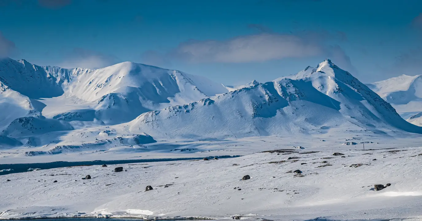 Snow-Covered Arctic Mountains and Glacier Valley A pristine Arctic landscape featuring majestic snow-capped mountains and a frozen valley with
