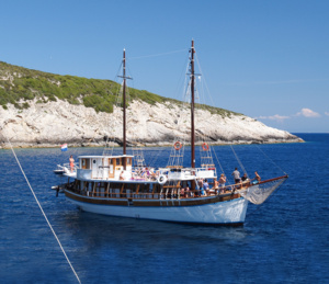 Traditional Gulet Sailing Boat in Mediterranean A classic wooden gulet sailing vessel anchored in crystal-clear turquoise Mediterranean waters