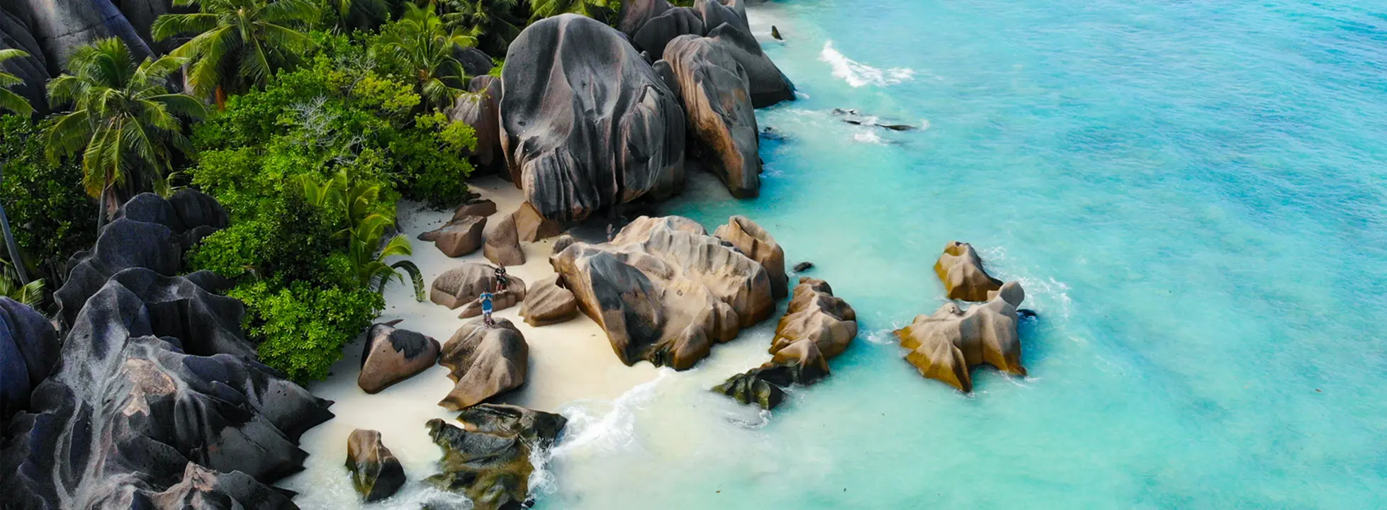 Tropical Paradise Beach with Granite Boulders A stunning tropical beach cove featuring distinctive large granite boulders scattered across