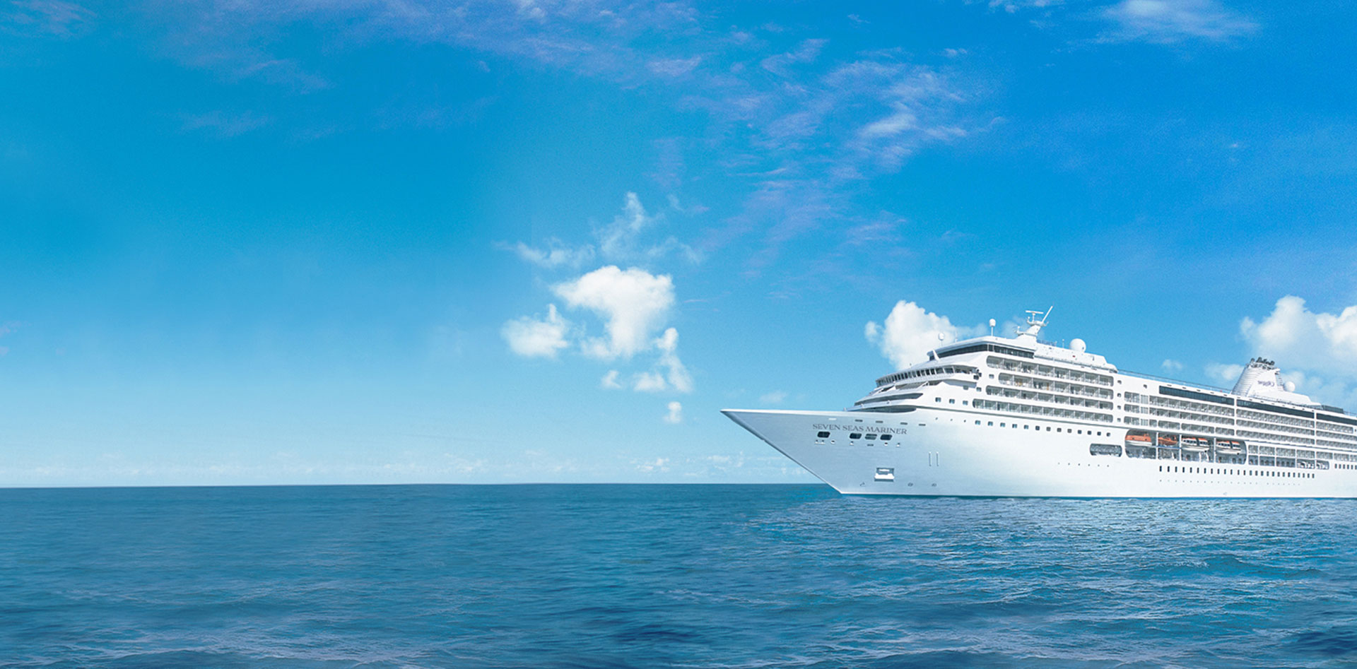 White Cruise Ship on Blue Ocean A large, white luxury cruise ship sailing on a calm, azure blue ocean under a bright, cloud-dotted sky. The vessel appears sleek and modern, cutting through pristine maritime waters.