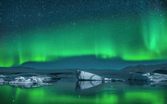 Northern Lights Over Jökulsárlón Glacier Lagoon A stunning display of vibrant green aurora borealis dancing across the night sky above a glacial