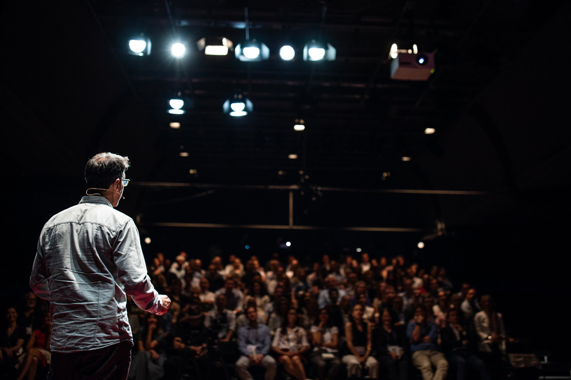 adobestock-224515728 A speaker addressing a large audience in a theater setting, representing corporate events and conferences at sea.
